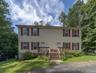 Two-story duplex with light-colored siding and red shutters