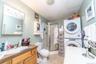 Vanity with an integrated sink, wood-finish cabinetry, and a wall-mounted mirror