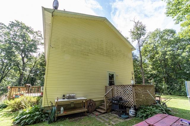 Siding exterior with a rear deck featuring wood lattice railing