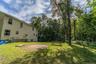 Expansive grassy yard with mature trees and a circular gravel patio area