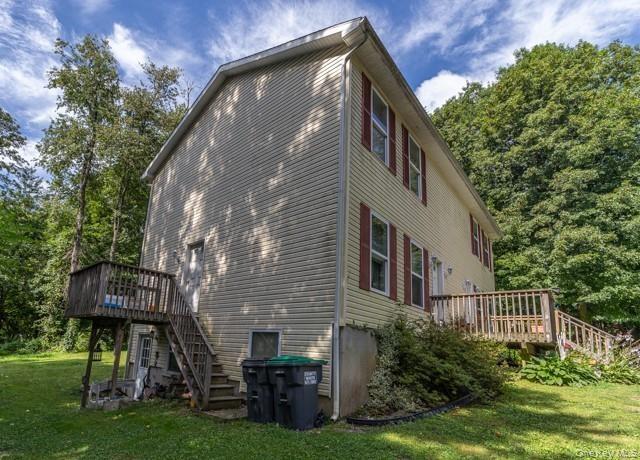 Two-story exterior with siding, featuring multiple windows with shutters and two wooden decks