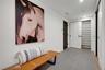 Spacious, beautifully organized mudroom with a full wall of custom storage closets, tucked behind stylish barn doors.