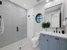 Bathroom with gray tile and round window