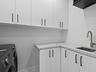 Laundry room with sink and cabinetry