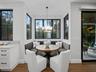 Dining nook with round table and black-framed windows