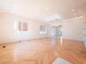Herringbone pattern wood-finish flooring, recessed ceiling lighting, cove lighting, and multiple windows