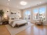 Wood-finish flooring, recessed lighting, ceiling-mounted light fixture, large windows, and a sliding glass door to an exterior balcony