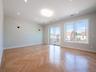 Herringbone wood-finish flooring, recessed lighting, and wall-mounted sconces