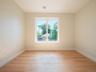 Hardwood-style flooring, white trim, recessed lighting, and a large window