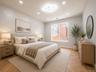 Recessed lighting, contemporary ceiling light fixture, wood-finish flooring with a herringbone pattern, large window, and light-toned walls