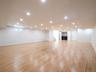 Expansive open-plan room with recessed lighting, wood-finish flooring, and white walls