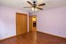Wood-finish flooring, ceiling fan with integrated lighting, wood-paneled bi-fold closet, and recessed doorway