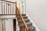 Carpeted staircase with wood-finish balusters and handrail