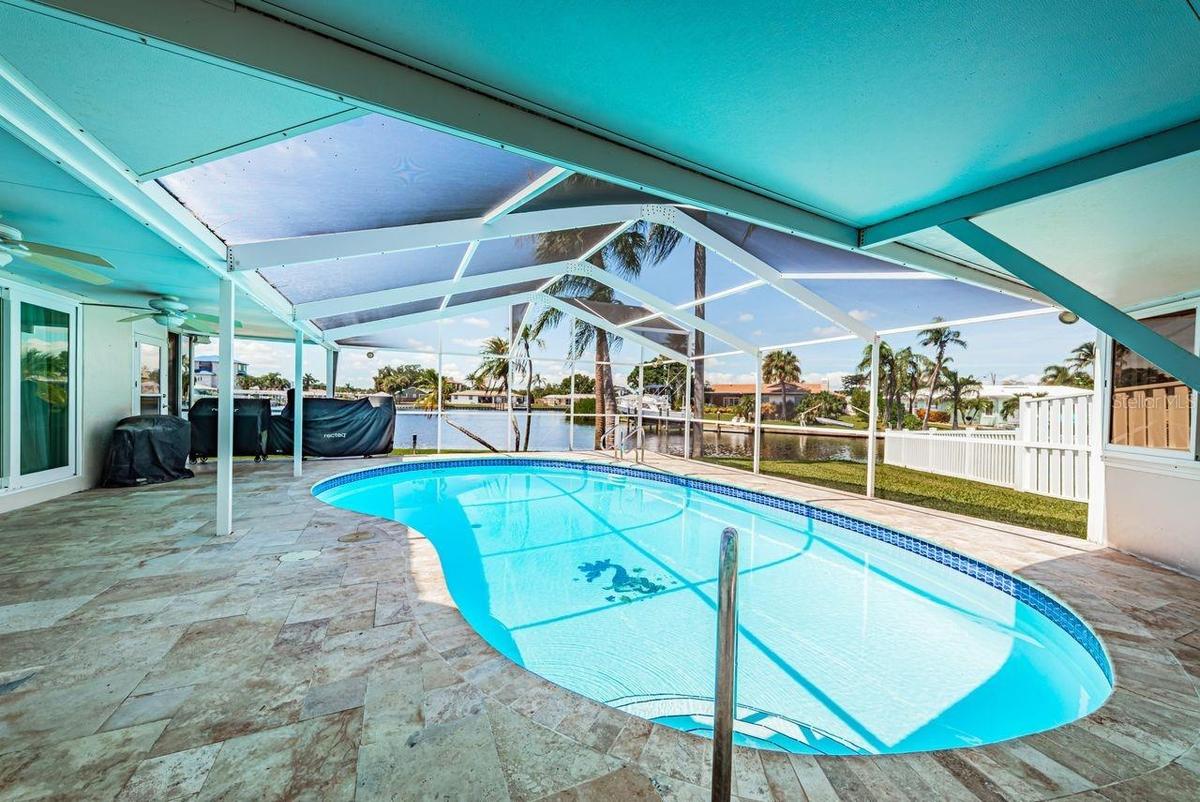 Travertine pavers surround the pool