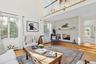 Living area with a brick fireplace, baseboard heating, and wood finished floors