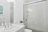 Full bathroom with vanity, a marble finish shower, and a skylight