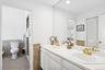 Full bathroom with double vanity, tile walls, wainscoting, a closet, and recessed lighting