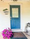 Lower apartment of two story structure in back of main house. with blue door and glass paneling