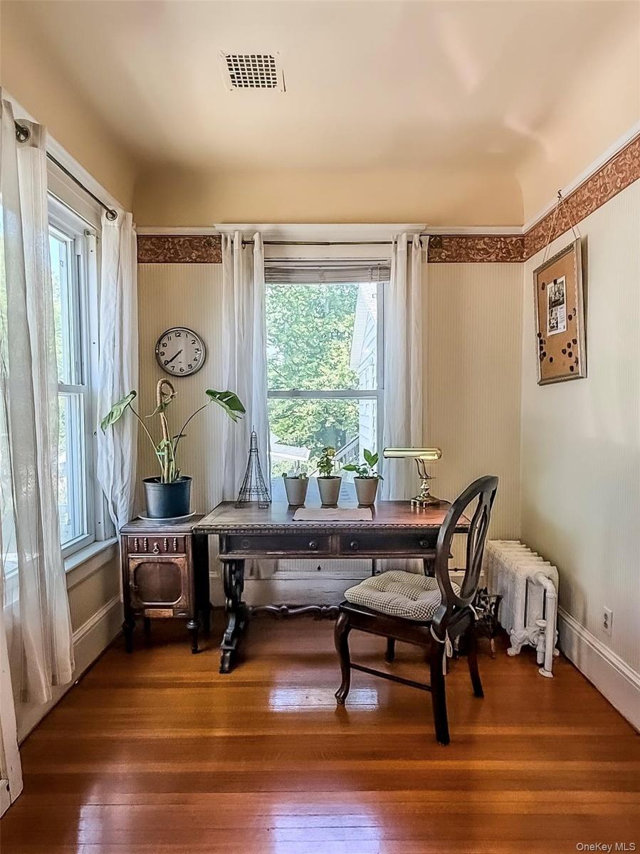 Office Nook off Dining Room with hardwood flooring, painted walls with decorative border and white trim