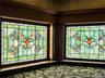 Three Story Stair Well Stained glass windows with intricate patterns, framed by rich wood millwork and crown molding