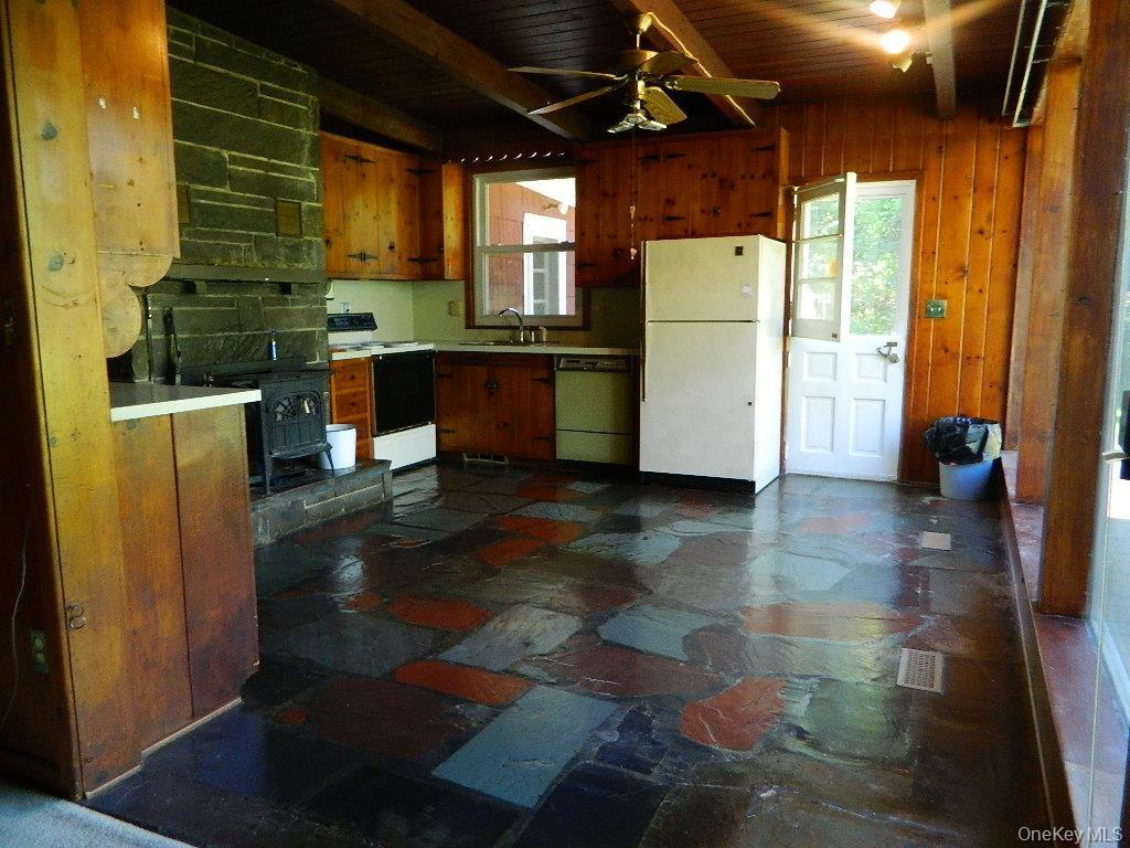 Charming kitchen with wood burning stove, slate floor, knotty pine cabinets and a dutch door!