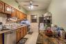 Wood-finish cabinetry paired with a refrigerator, gas range, and dishwasher.