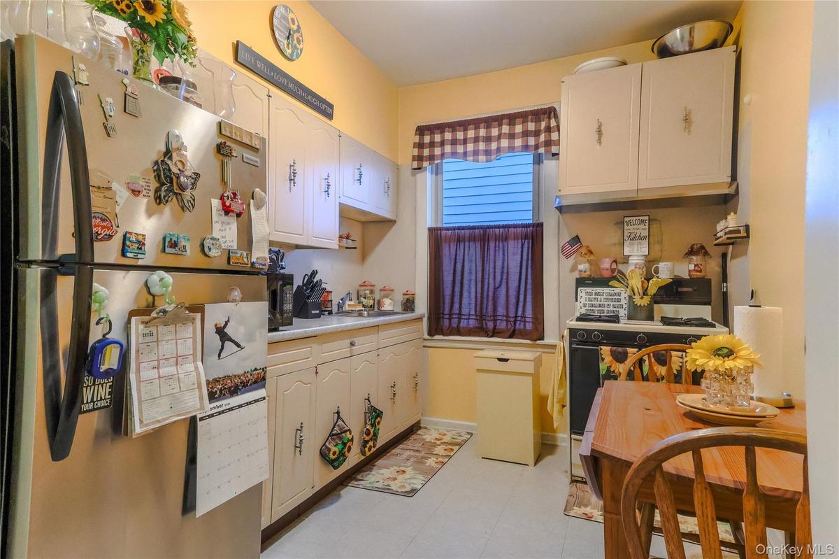 Kitchen featuring a stainless steel refrigerator, cream-colored cabinetry, and a window