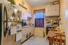 Kitchen featuring a stainless steel refrigerator, cream-colored cabinetry, and a window