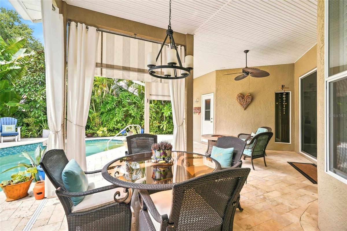 Cabana-style curtains frame the covered patio peering to the pool.