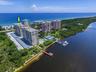 Waterfront high-rise building featuring a marina, swimming pool, and tennis courts
