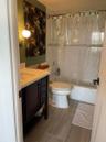 White tiled shower with a decorative accent band