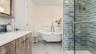 Primary ensuite bathroom with double vanity, tiled steam shower and soaking tub.