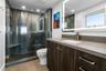 Luxurious guest suite bathroom with a marble walk in shower, light up mirror and custom cabinetry.