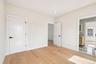 Light wood-finish flooring, recessed ceiling lighting, two-panel interior doors with black hardware, white baseboards