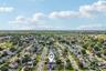 Expansive residential area featuring numerous single-family homes, mature trees lining streets, and visible athletic fields