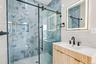 Shower with blue marble-effect tile and sliding glass door