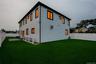 Fenced yard with artificial turf, a paver patio, and a two-story exterior featuring white siding and black trim windows