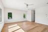 Light wood-finish flooring, recessed lighting, white walls, multiple windows, and a modern ceiling fan