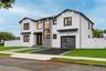 Contemporary exterior featuring white vertical siding and dark-trimmed windows
