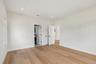 Recessed lighting, wood-finish flooring, white walls, white trim, and white doors with matte black hardware