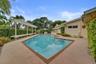 Rectangular pool with an integrated spa, surrounded by aggregate-finish decking