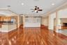 Hardwood flooring, recessed lighting, built-in cabinetry, kitchen island with dark countertop, stainless steel refrigerator