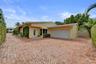 Driveway features plenty of space, leads to two-car garage, brick paver driveway, and mature landscaping.