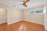 Wood-finish flooring, crown molding, a ceiling fan with integrated lighting, recessed lighting, and horizontal windows with plantation shutters