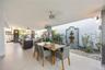 Private covered terrace with ceiling fans, outdoor dining, and a soothing water fountain that fills the space with a peaceful sound