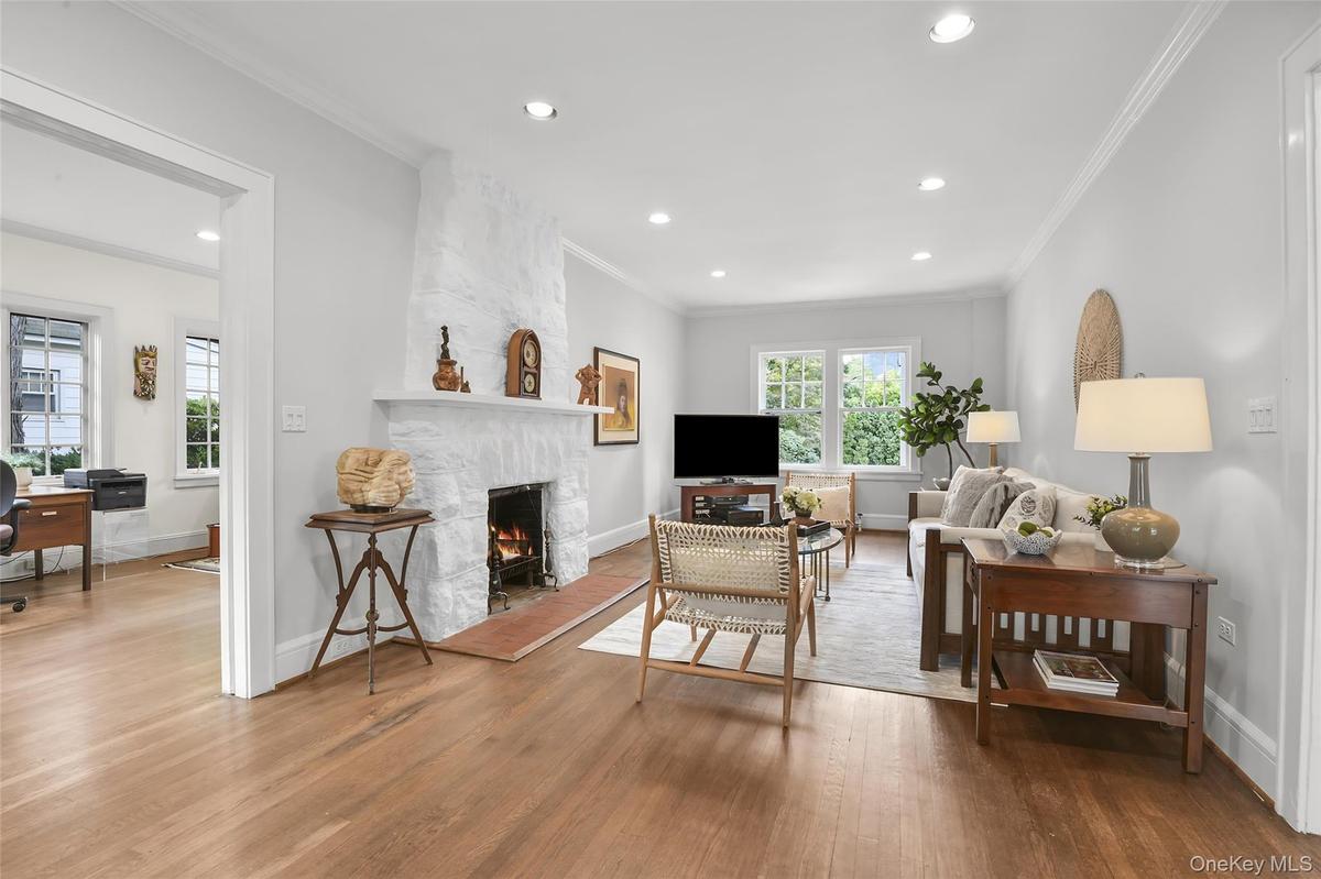 Living room has front to back windows, hardwood flooring and recessed lighting.
