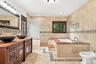 A marble-and-granite bath worthy of the primary suite.