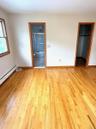 Primary bedroom/Primary bath and walk-in closet, baseboard heating unit, light wood-style floors, and a spacious closet