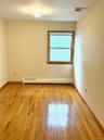 Empty room featuring light wood-style flooring and a baseboard heating unit