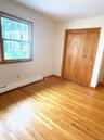 Unfurnished bedroom featuring a baseboard radiator, light wood-type flooring, and a closet